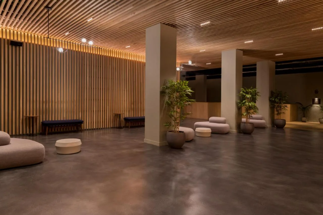 a lobby with a row of plants and chairs at Zedwell Hotel Piccadilly Circus in London