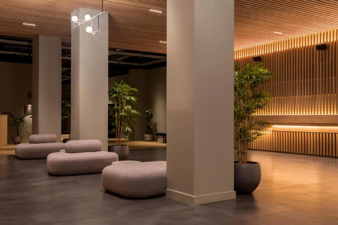 a lobby with a row of stools and potted plants at Zedwell Hotel Piccadilly Circus in London